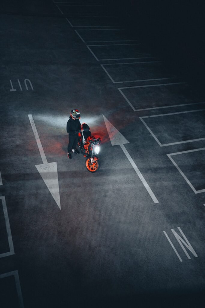 A person with a motorcycle in a parking lot.